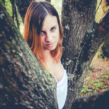 Portrait d'une jeune femme au creux d'un arbre