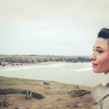 Portrait d'une jeune femme regardant le lointain en bord de mer